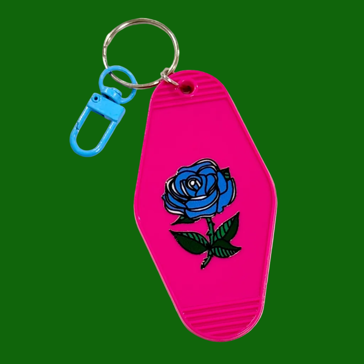 Pink keychain with blue rose design on a green background