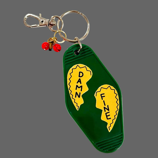 Keychain with green tag featuring yellow text 'Damn' and 'Fine' on a grey background