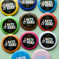 Assorted colorful buttons with 'I HATE IT HERE' text on a green background